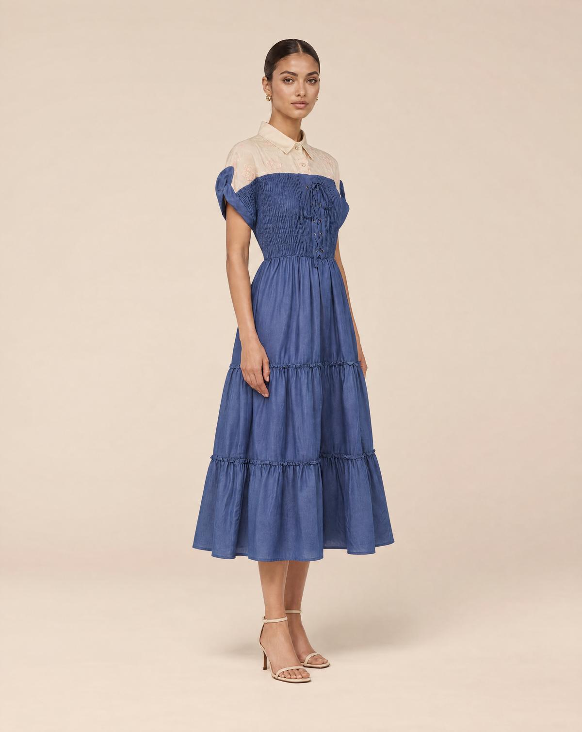 An elegant dress with embroidered floral details and smocking
