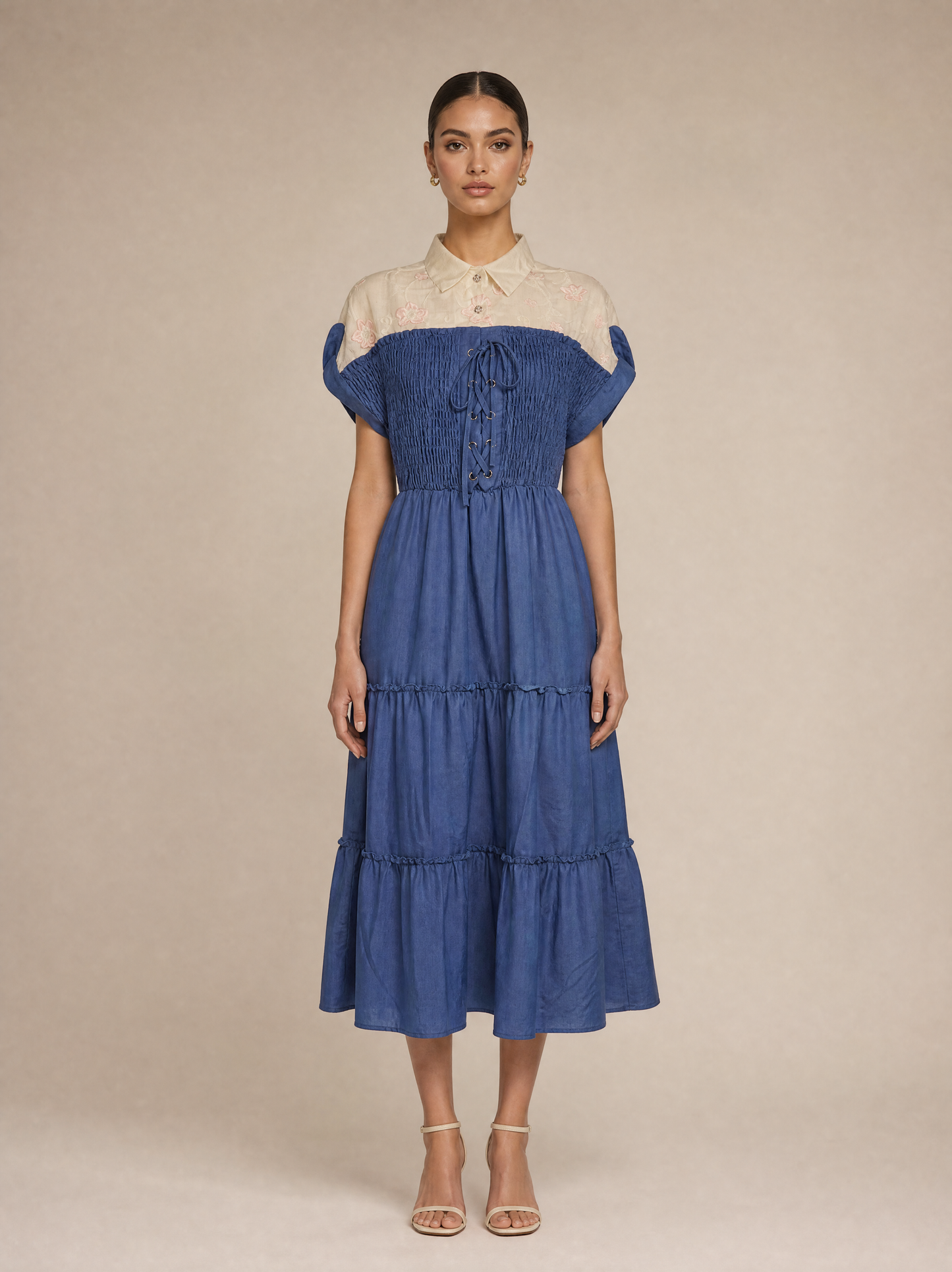 An elegant dress with embroidered floral details and smocking