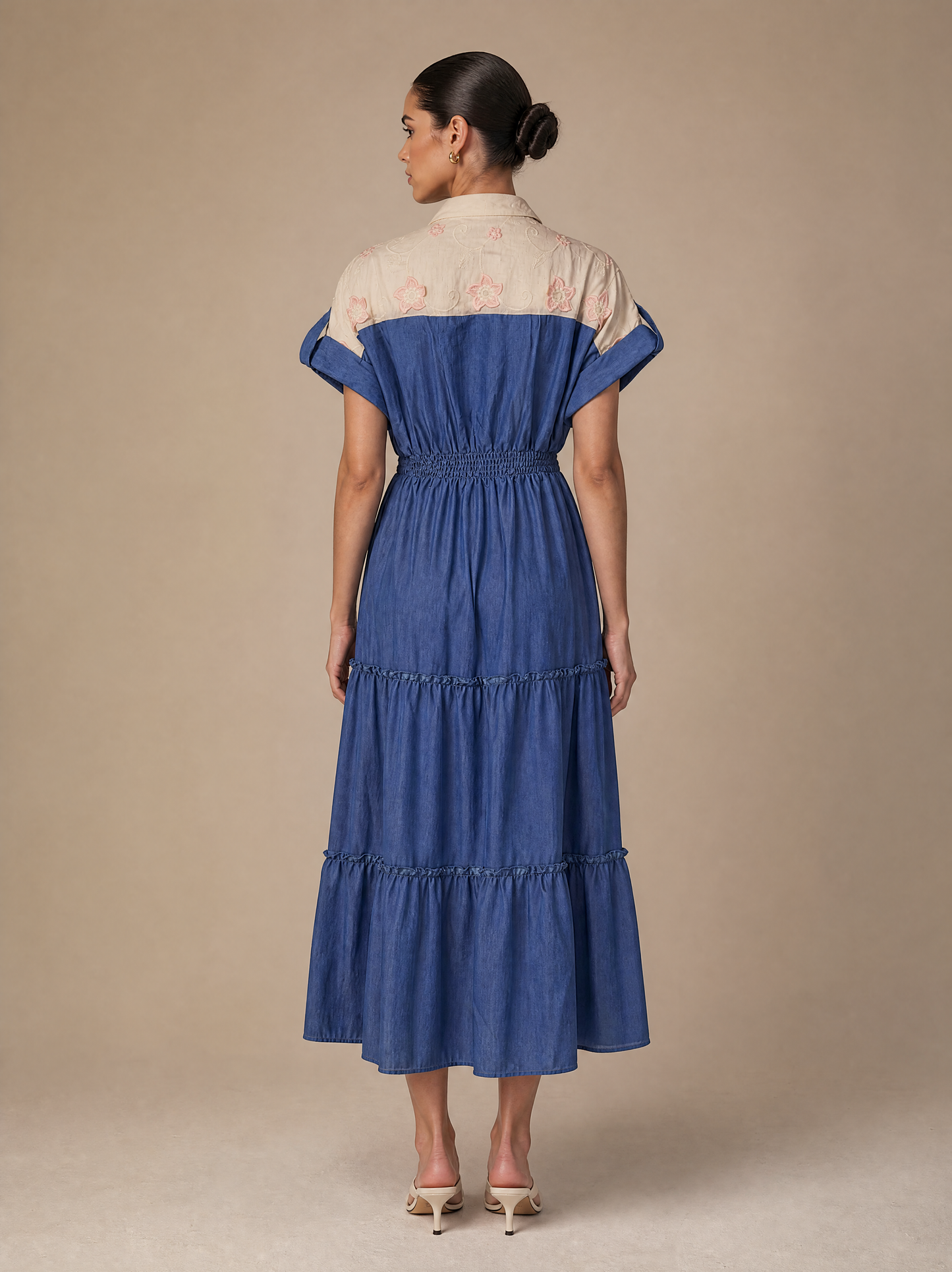 An elegant dress with embroidered floral details and smocking
